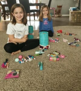 Girls help sort through their bathroom stuff